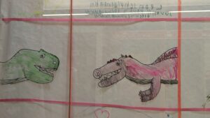 Das Bild zeigt zwei Drachen, die von Kindern gemalt wurden,